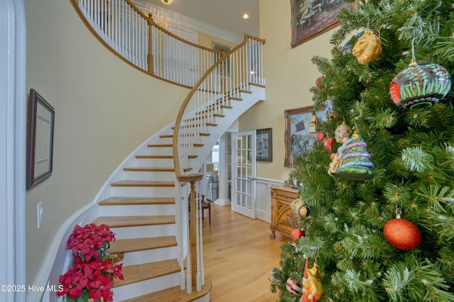 4 Hunter Heath Dr, North Topsail Beach, NC 28460 - staircase with wood finished floors, a high ceiling, and wainscoting
