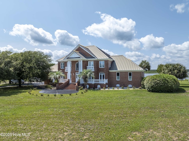 4 Hunter Heath Dr, North Topsail Beach, NC 28460 - view of front of property with a standing seam roof, a front yard, a metal roof, and brick siding