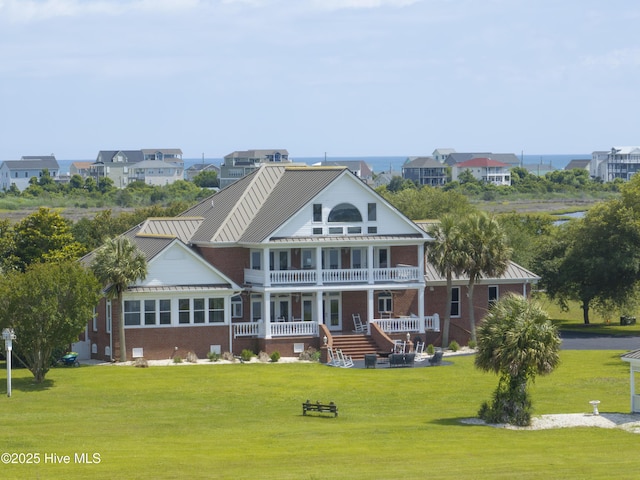 4 Hunter Heath Dr, North Topsail Beach, NC 28460 - back of house featuring a porch, a balcony, brick siding, a lawn, and stairs