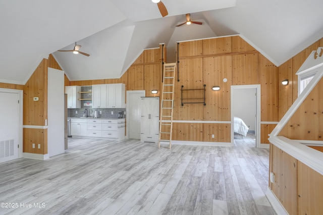 4 Hunter Heath Dr, North Topsail Beach, NC 28460 - kitchen featuring ceiling fan, wood walls, lofted ceiling, white cabinetry, and light wood-type flooring