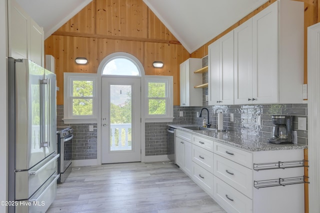 4 Hunter Heath Dr, North Topsail Beach, NC 28460 - kitchen with stainless steel appliances, lofted ceiling, open shelves, light stone countertops, and white cabinets
