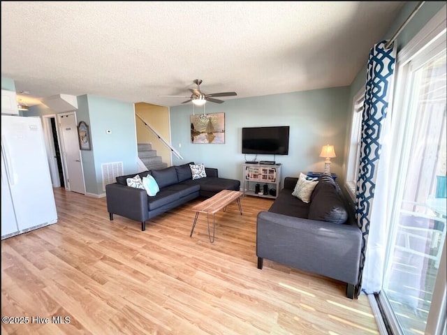 7411 Ocean Dr Unit E & W, Emerald Isle, NC 28594 - living area featuring a textured ceiling, light wood-type flooring, stairway, ceiling fan, and baseboards