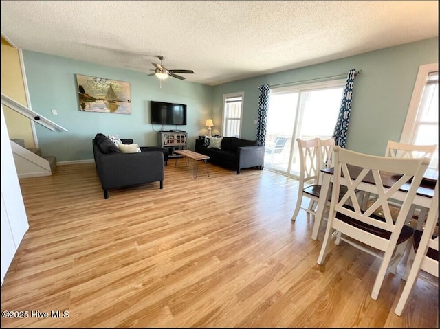 7411 Ocean Dr Unit E & W, Emerald Isle, NC 28594 - living room with a textured ceiling, light wood-type flooring, ceiling fan, stairway, and baseboards