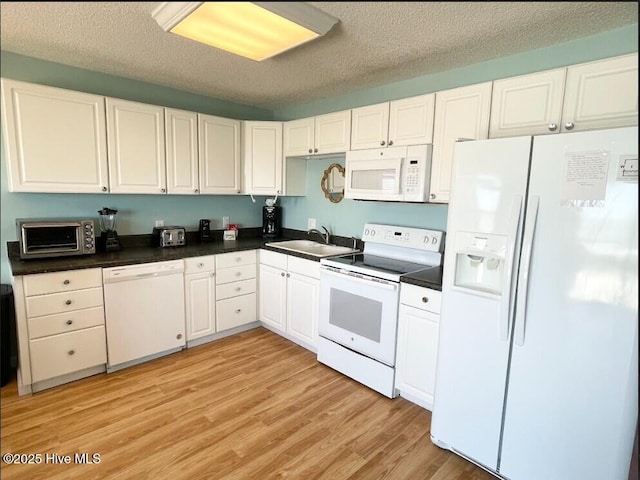 7411 Ocean Dr Unit E & W, Emerald Isle, NC 28594 - kitchen featuring white appliances, a sink, dark countertops, a textured ceiling, and light wood finished floors