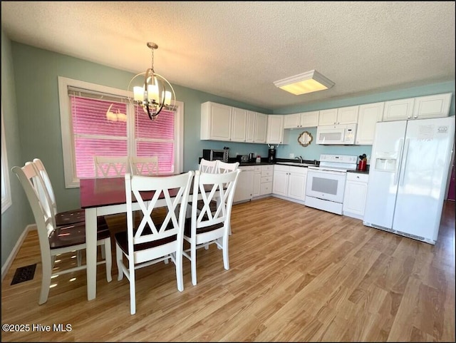 7411 Ocean Dr Unit E & W, Emerald Isle, NC 28594 - kitchen featuring white appliances, a chandelier, a textured ceiling, a sink, and light wood-type flooring