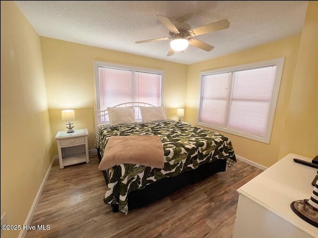 7411 Ocean Dr Unit E & W, Emerald Isle, NC 28594 - bedroom with multiple windows, wood finished floors, baseboards, a textured ceiling, and ceiling fan