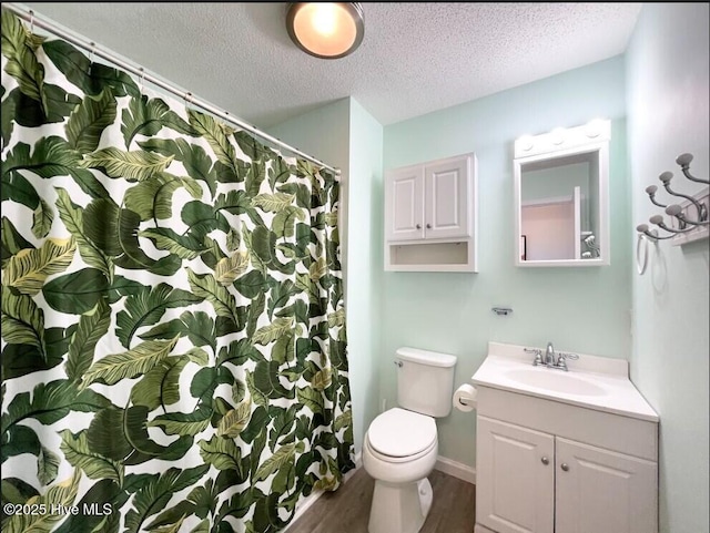 7411 Ocean Dr Unit E & W, Emerald Isle, NC 28594 - bathroom with a textured ceiling, wood finished floors, vanity, toilet, and a shower with curtain