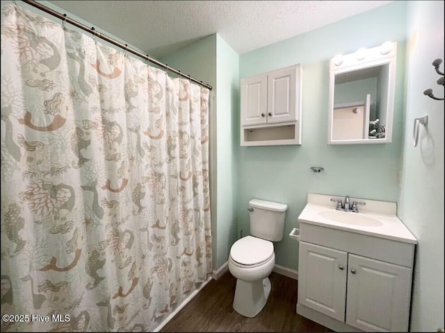 7411 Ocean Dr Unit E & W, Emerald Isle, NC 28594 - bathroom with wood finished floors, a textured ceiling, vanity, toilet, and baseboards