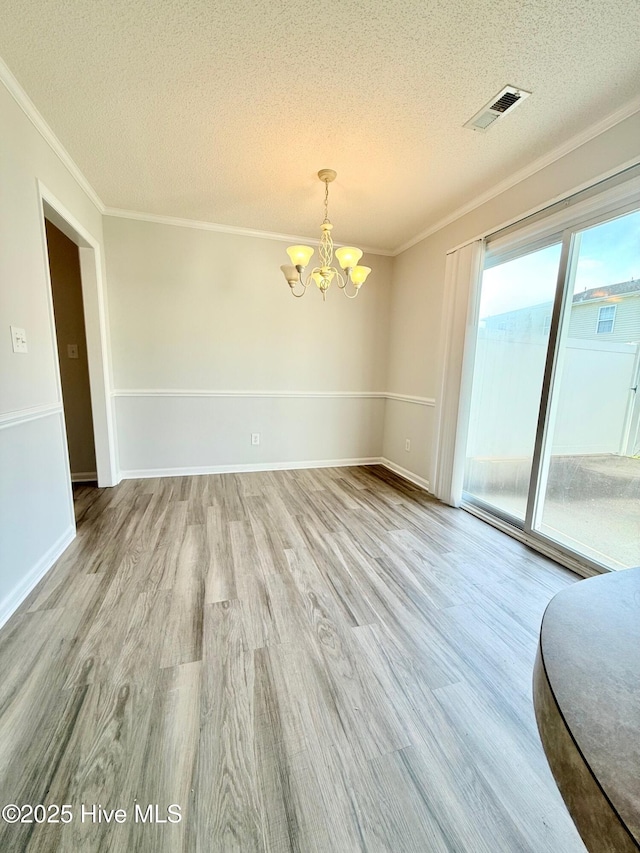 2104 Flagstone Ct Unit A-4, Greenville, NC 27834 - unfurnished dining area with a chandelier, a textured ceiling, wood finished floors, ornamental molding, and baseboards
