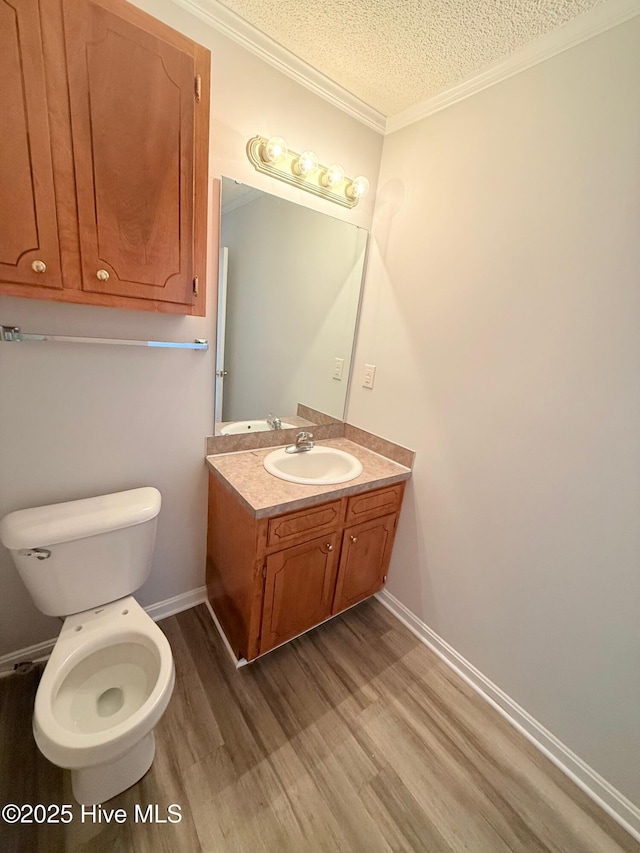 2104 Flagstone Ct Unit A-4, Greenville, NC 27834 - bathroom featuring wood finished floors, vanity, a textured ceiling, ornamental molding, and toilet