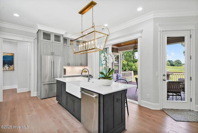 1830 Senova Trce, Wilmington, NC 28405 - kitchen featuring stainless steel appliances, light countertops, a chandelier, light wood-style flooring, and a kitchen island with sink