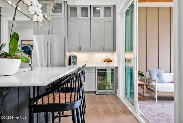 1830 Senova Trce, Wilmington, NC 28405 - kitchen with beverage cooler, freestanding refrigerator, light countertops, a chandelier, and tasteful backsplash