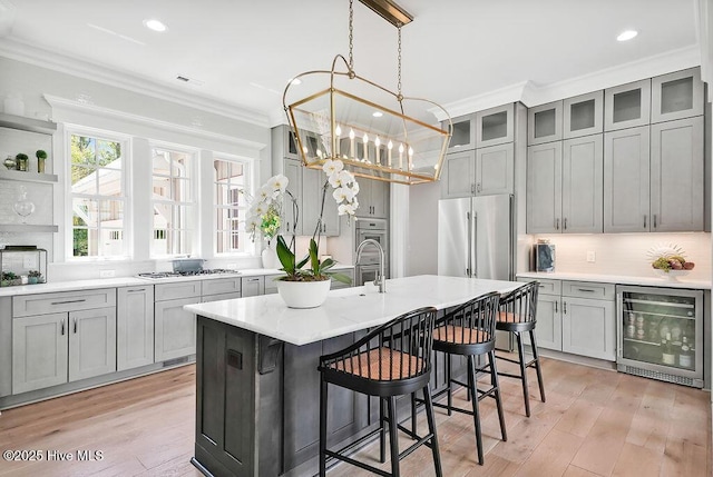 1830 Senova Trce, Wilmington, NC 28405 - kitchen featuring beverage cooler, stainless steel appliances, gray cabinetry, crown molding, and light wood-style flooring
