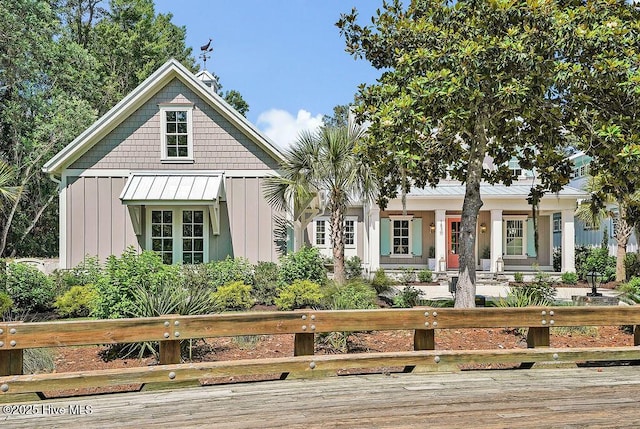 1830 Senova Trce, Wilmington, NC 28405 - view of front of home with covered porch, a standing seam roof, board and batten siding, a fenced front yard, and a metal roof
