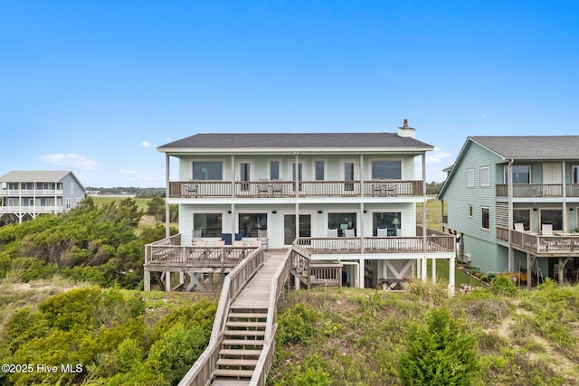 1239 Ocean Blvd W, Holden Beach, NC 28462 - rear view of property featuring a balcony, a chimney, stairway, and a shingled roof