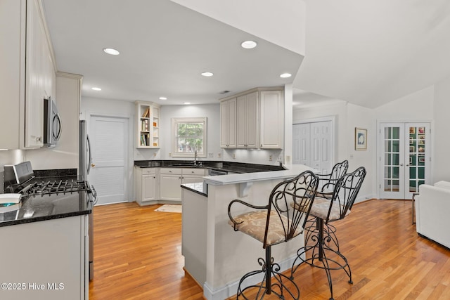 5752 Gardenia Ln, Wilmington, NC 28409 - kitchen featuring stainless steel microwave, a kitchen bar, gas range, a peninsula, and recessed lighting