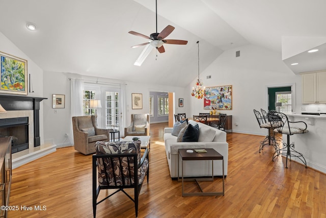 5752 Gardenia Ln, Wilmington, NC 28409 - living area with a ceiling fan, light wood-style flooring, a tiled fireplace, recessed lighting, and high vaulted ceiling