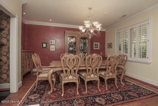 1 Burton Pl, Jacksonville, NC 28540 - dining space with a chandelier, wood finished floors, crown molding, and an accent wall