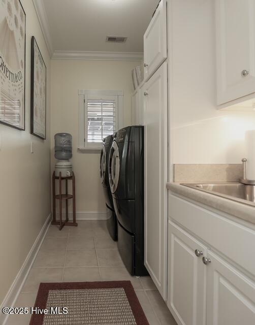 1 Burton Pl, Jacksonville, NC 28540 - laundry room featuring independent washer and dryer, cabinet space, light tile patterned flooring, and crown molding