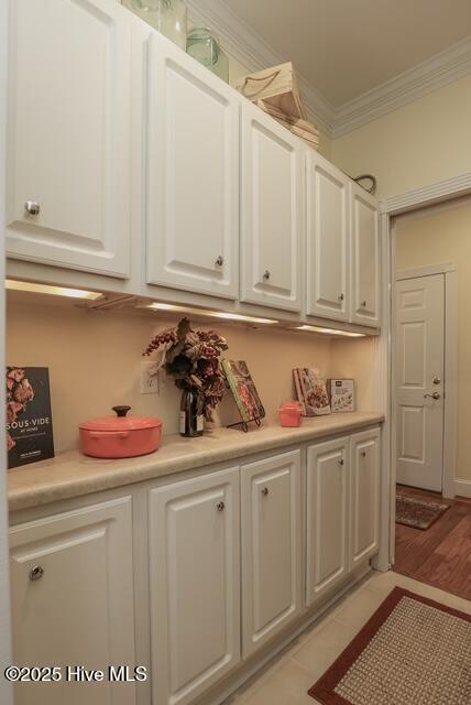 1 Burton Pl, Jacksonville, NC 28540 - kitchen featuring ornamental molding, white cabinets, light countertops, and light wood-style flooring