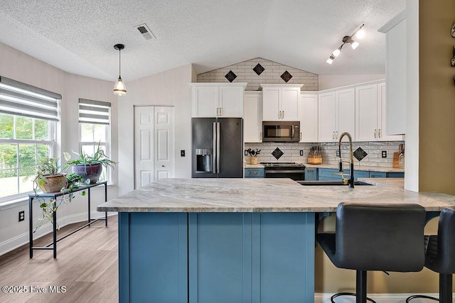 648 Pine Branches Cir SE, Leland, NC 28451 - kitchen featuring stainless steel microwave, fridge with ice dispenser, vaulted ceiling, electric range, and light wood-style floors