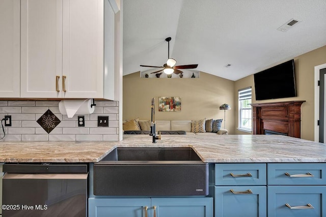 648 Pine Branches Cir SE, Leland, NC 28451 - kitchen with dishwashing machine, a ceiling fan, open floor plan, blue cabinets, and backsplash