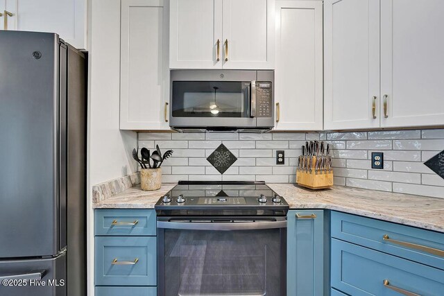 648 Pine Branches Cir SE, Leland, NC 28451 - kitchen with stainless steel appliances, white cabinets, decorative backsplash, and light stone counters