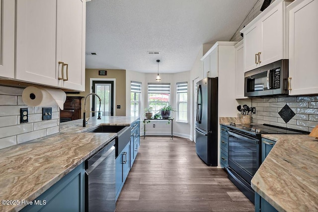 648 Pine Branches Cir SE, Leland, NC 28451 - kitchen featuring stainless steel appliances, blue cabinets, white cabinets, a textured ceiling, and dark wood-style flooring