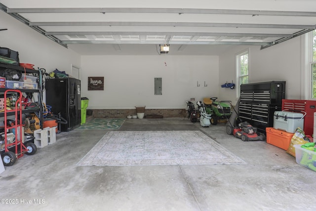637 White Oak Xing, Swansboro, NC 28584 - garage with a garage door opener, electric panel, and black refrigerator with ice dispenser