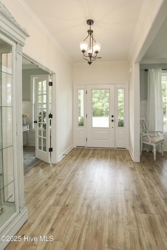 637 White Oak Xing, Swansboro, NC 28584 - foyer entrance featuring a chandelier, crown molding, healthy amount of natural light, and light wood-style flooring