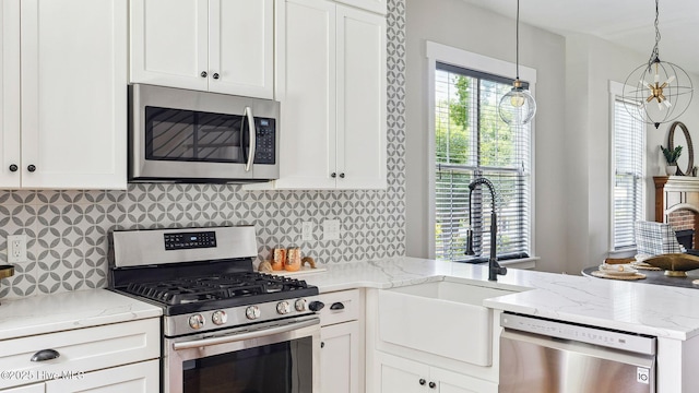 359 N Leak St, Southern Pines, NC 28387 - kitchen featuring appliances with stainless steel finishes, a sink, white cabinets, a peninsula, and light stone counters