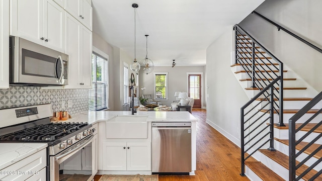 359 N Leak St, Southern Pines, NC 28387 - kitchen featuring stainless steel appliances, a sink, a peninsula, decorative backsplash, and white cabinets