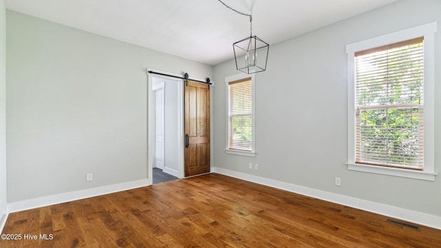 359 N Leak St, Southern Pines, NC 28387 - unfurnished room with a barn door, baseboards, and dark wood-style flooring