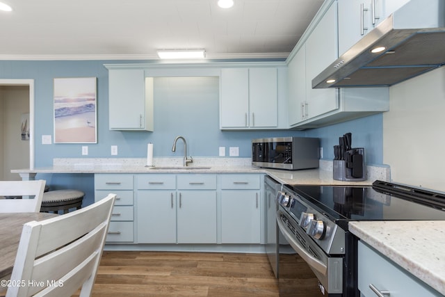901 Ocean Dr, Emerald Isle, NC 28594 - kitchen featuring appliances with stainless steel finishes, a sink, under cabinet range hood, ornamental molding, and wood finished floors