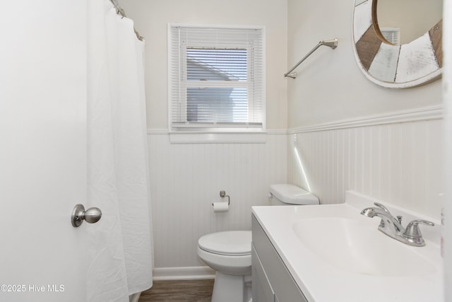 901 Ocean Dr, Emerald Isle, NC 28594 - full bath with wainscoting, toilet, wood finished floors, and vanity