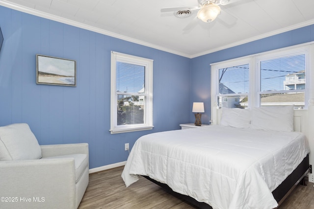 901 Ocean Dr, Emerald Isle, NC 28594 - bedroom with multiple windows, wood finished floors, ornamental molding, a ceiling fan, and baseboards