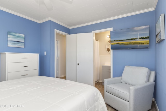 901 Ocean Dr, Emerald Isle, NC 28594 - bedroom featuring crown molding, wood finished floors, connected bathroom, and a decorative wall