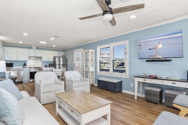 901 Ocean Dr, Emerald Isle, NC 28594 - living area featuring a ceiling fan, wood finished floors, crown molding, baseboards, and recessed lighting