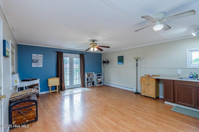 503 Vandemere Rd, Bayboro, NC 28515 - living room with a baseboard radiator, a ceiling fan, french doors, light wood-type flooring, and a wainscoted wall