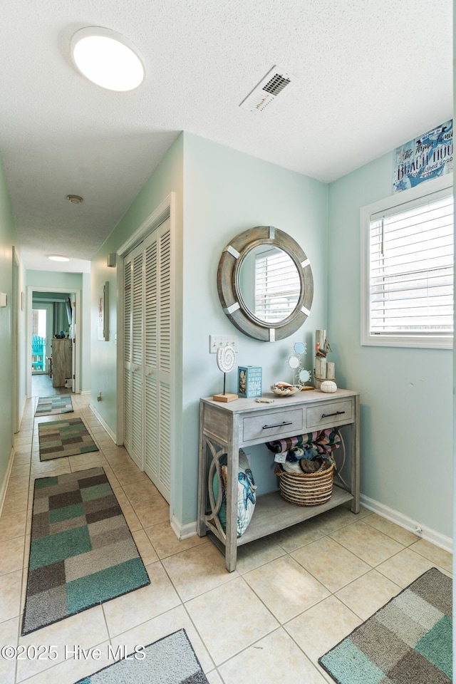 2310 New River Inlet Rd Unit 1, North Topsail Beach, NC 28460 - hallway with tile patterned floors, plenty of natural light, and a textured ceiling