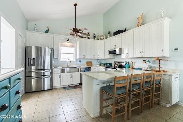 2310 New River Inlet Rd Unit 1, North Topsail Beach, NC 28460 - kitchen featuring appliances with stainless steel finishes, light countertops, a peninsula, white cabinetry, and a ceiling fan