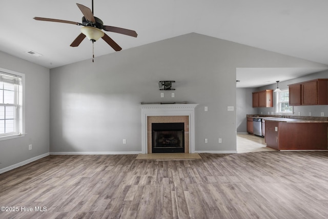 308 Big Tree Ln, Chinquapin, NC 28521 - unfurnished living room featuring vaulted ceiling, light wood-style flooring, a ceiling fan, and a fireplace with flush hearth