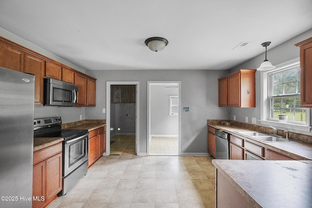 308 Big Tree Ln, Chinquapin, NC 28521 - kitchen with appliances with stainless steel finishes, decorative light fixtures, and brown cabinets