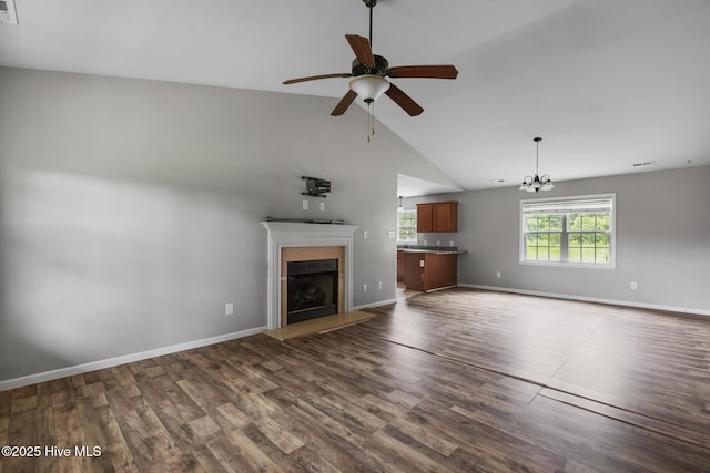 308 Big Tree Ln, Chinquapin, NC 28521 - unfurnished living room with ceiling fan, a fireplace with raised hearth, dark wood-type flooring, high vaulted ceiling, and a chandelier