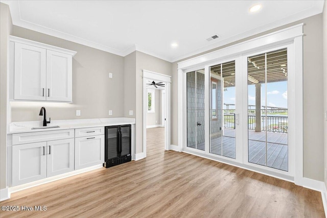 1711 Hemingway Dr SW, Ocean Isle Beach, NC 28469 - kitchen with beverage cooler, a sink, light wood-style floors, light countertops, and baseboards