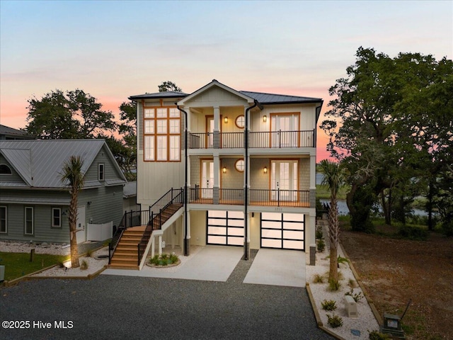 1711 Hemingway Dr SW, Ocean Isle Beach, NC 28469 - view of front of house featuring a balcony, stairs, french doors, an attached garage, and driveway