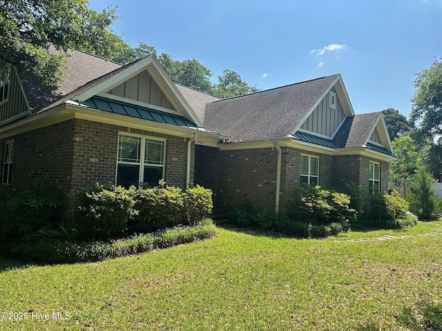 2790 Scotts Hill Loop Rd, Wilmington, NC 28411 - view of side of home featuring board and batten siding, brick siding, a yard, and a shingled roof