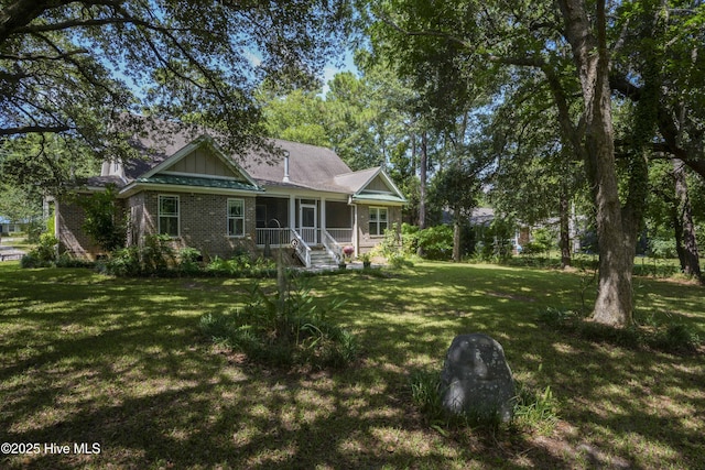 2790 Scotts Hill Loop Rd, Wilmington, NC 28411 - rear view of property featuring brick siding, a lawn, and covered porch