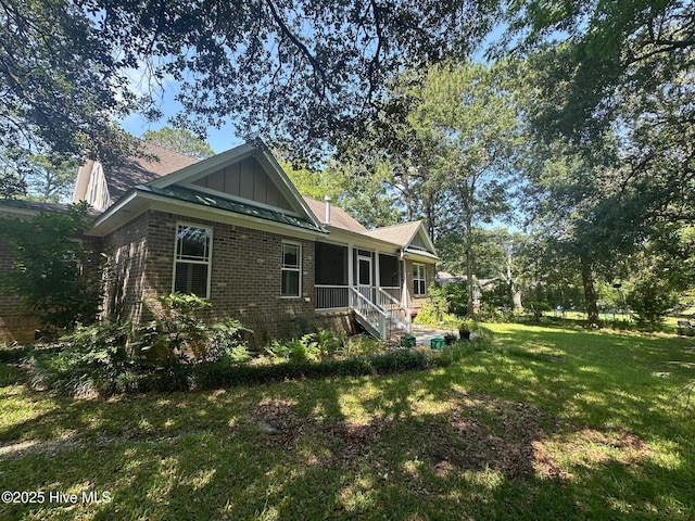 2790 Scotts Hill Loop Rd, Wilmington, NC 28411 - rear view of house featuring board and batten siding, brick siding, and a lawn