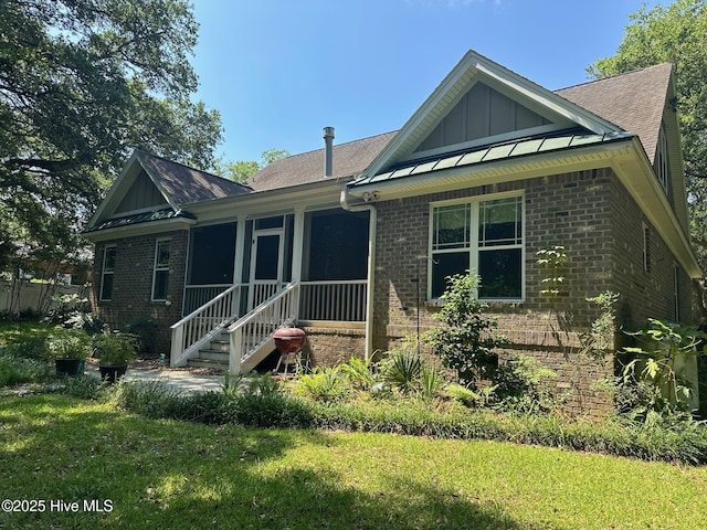 2790 Scotts Hill Loop Rd, Wilmington, NC 28411 - view of front of home with brick siding, a front yard, board and batten siding, and roof with shingles